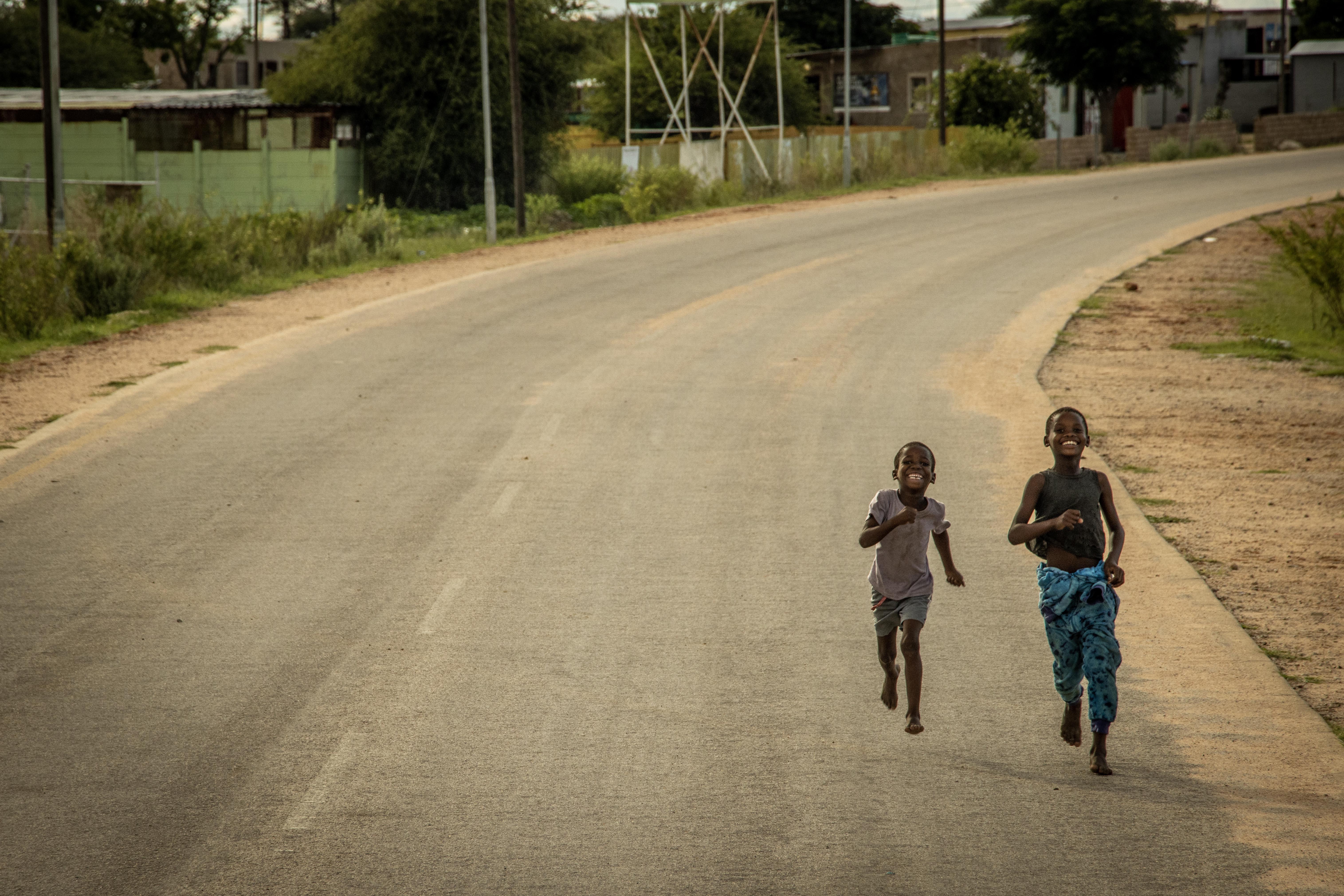 Children running along a road in a Namibian community