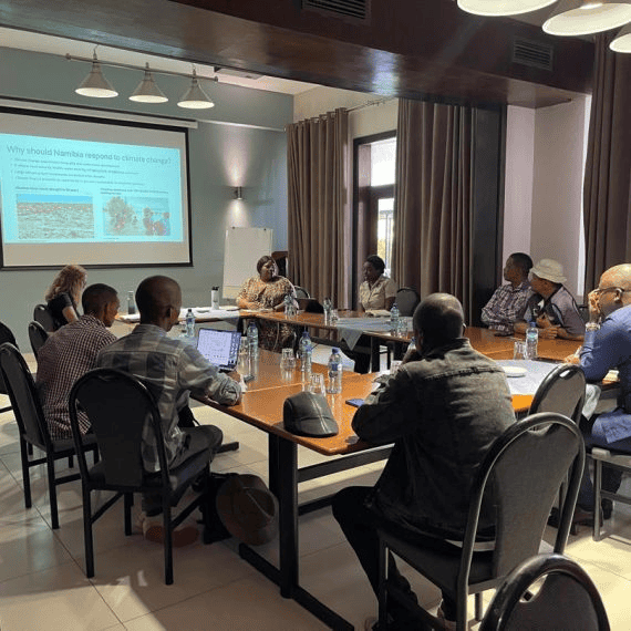 Participants discussing climate adaptation around a meeting table.