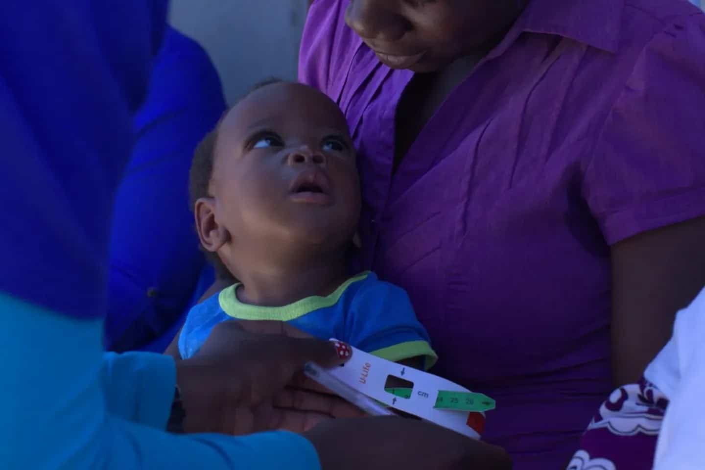 A child having their upper arm measured during a nutrition assessment