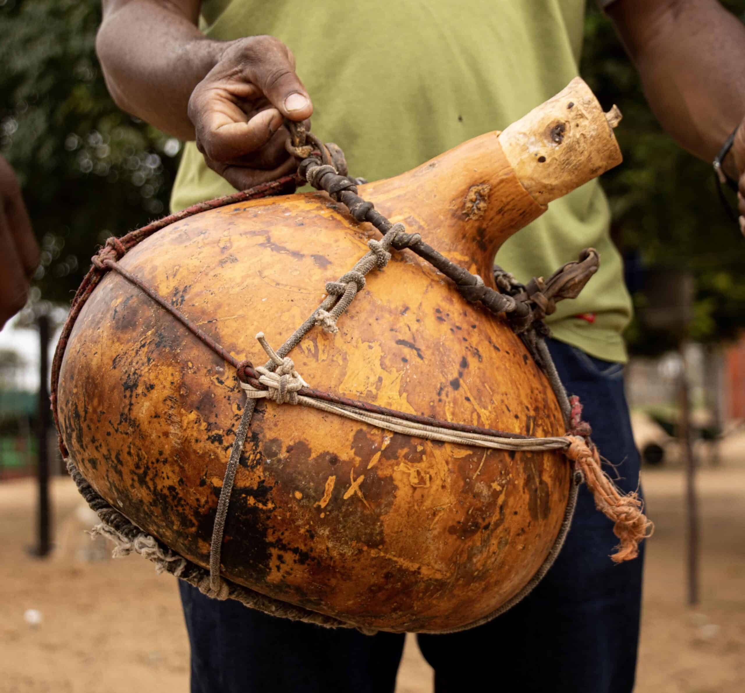 A person holding a traditional gourd container.